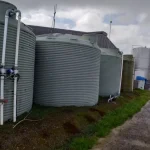Large water storage tanks with connected piping for rural water supply management
