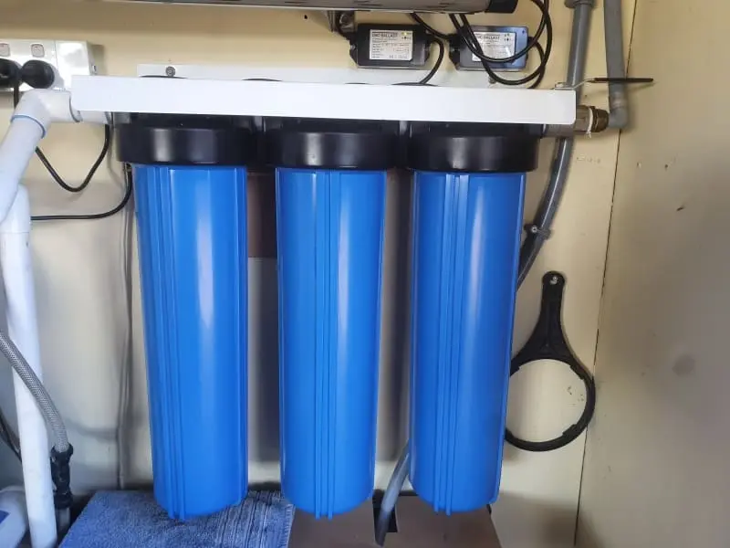 Triple water filtration system with three blue filter housings for clean water supply -Water Services NZ